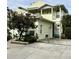 Two-story yellow house with a balcony and a tree in the front at 458 Grant St, Dunedin, FL 34698