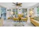 Sunlit living room with two yellow sofas and a glass coffee table at 6390 115Th Ln, Seminole, FL 33772