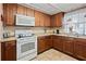 Updated kitchen with wood cabinets and white appliances at 7050 El Matador St, Zephyrhills, FL 33541