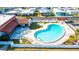 Aerial view of community pool, clubhouse, and surrounding landscape at 7050 El Matador St, Zephyrhills, FL 33541