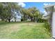 Large backyard with mature trees and grassy lawn at 8130 Merrimac Dr, Port Richey, FL 34668