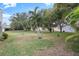 Expansive backyard, featuring lush greenery and palm trees at 8130 Merrimac Dr, Port Richey, FL 34668