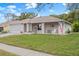 Brick ranch home with a screened-in garage and American flag at 8130 Merrimac Dr, Port Richey, FL 34668