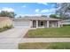 Cute ranch home with a screened-in garage and well-manicured lawn at 8130 Merrimac Dr, Port Richey, FL 34668