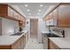 Modern kitchen with wood cabinets, stainless steel appliances, and white countertops at 8130 Merrimac Dr, Port Richey, FL 34668