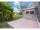 Pink patio area with screened enclosure and lush landscaping at 8130 Merrimac Dr, Port Richey, FL 34668