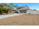 House exterior featuring a two-car garage and a well-maintained lawn at 8382 Windridge Way, Weeki Wachee, FL 34613