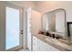 Modern bathroom with white cabinets, granite countertop, and large mirror at 8459 Harvey Walden Dr, Plant City, FL 33565