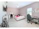 Bright bedroom with a queen bed, desk and chair, and a TV at 8459 Harvey Walden Dr, Plant City, FL 33565