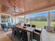 Covered patio with dining and seating areas, wooden ceiling and large backyard at 8459 Harvey Walden Dr, Plant City, FL 33565