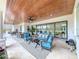 Relaxing covered patio with seating area, dining table, and wood ceiling at 8459 Harvey Walden Dr, Plant City, FL 33565