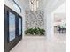 Bright entry with modern double doors, stone feature wall, and potted plants at 8459 Harvey Walden Dr, Plant City, FL 33565