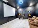 Home theater with projector screen, three guitars, and comfortable seating at 8459 Harvey Walden Dr, Plant City, FL 33565