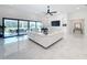 Open living room with white sectional sofa, large TV, and access to patio at 8459 Harvey Walden Dr, Plant City, FL 33565