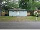 Light green house with a small front yard and mature trees at 8514 N Branch Ave, Tampa, FL 33604