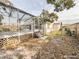 Backyard view of home with deck and screened enclosure at 9825 Lakeside Ln, Port Richey, FL 34668