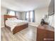 Bedroom with wooden bed frame and two windows at 9825 Lakeside Ln, Port Richey, FL 34668