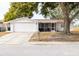 White brick ranch house with attached garage and screened porch at 9825 Lakeside Ln, Port Richey, FL 34668