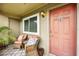 Condo entrance with patio furniture and a coral-colored door at 10263 Gandy N Blvd # 2206, St Petersburg, FL 33702