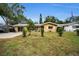 Tan single-story house with American flag and landscaping at 1034 Sunnydale Dr, Clearwater, FL 33755