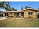 Tan single-story house with teal front door and landscaping at 1034 Sunnydale Dr, Clearwater, FL 33755