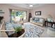 Living room with wicker sofas, floral rug, and large window at 1034 Sunnydale Dr, Clearwater, FL 33755