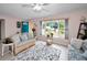 Bright living room featuring a floral rug and comfy wicker sofas at 1034 Sunnydale Dr, Clearwater, FL 33755