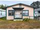 Tan house with teal accents, front porch, and small yard at 1106 Carlton St, Clearwater, FL 33755