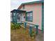 Side view of a tan house with teal accents and ramp at 1106 Carlton St, Clearwater, FL 33755