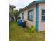 Side of house with teal accents and trash cans at 1106 Carlton St, Clearwater, FL 33755