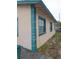 Side of house with teal accents and window at 1106 Carlton St, Clearwater, FL 33755