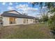 Large backyard with view of home's exterior and screened porch at 12413 Gunstock Ln, Hudson, FL 34667