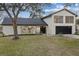 Contemporary home with stylish facade, landscaping, and a teal chair at 12413 Gunstock Ln, Hudson, FL 34667