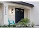 Stylish front entrance with a teal chair, modern door, and updated light at 12413 Gunstock Ln, Hudson, FL 34667