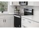 Modern kitchen features sleek black stovetop and white cabinets at 12413 Gunstock Ln, Hudson, FL 34667