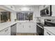 Modern white kitchen with stainless steel appliances and quartz countertops at 12413 Gunstock Ln, Hudson, FL 34667