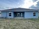 Rear view of single story home with covered patio at 13251 Ogden Glade Rd, Dade City, FL 33525