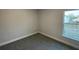 Bright bedroom with a window and gray carpet at 13287 Ogden Glade Rd, Dade City, FL 33525