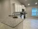 Modern kitchen with white cabinets, granite countertops, and breakfast bar at 13287 Ogden Glade Rd, Dade City, FL 33525