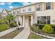 Two-story townhome with light beige siding, double door entry, and landscaping at 13630 Forest Lake Dr, Largo, FL 33771