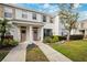 Two-story townhouse with a manicured lawn and walkway at 13630 Forest Lake Dr, Largo, FL 33771