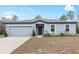 House exterior featuring a two-car garage and landscaping at 16125 Magpie Rd, Weeki Wachee, FL 34614