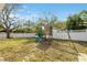 Backyard with playset, mature trees, and white fence at 1695 Honeybear Ln, Dunedin, FL 34698