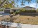 Front yard view of a house with a gray garage door and landscaping at 1695 Honeybear Ln, Dunedin, FL 34698