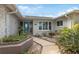 Front entry with a blue door, landscaping, and walkway at 1695 Honeybear Ln, Dunedin, FL 34698