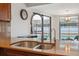 Modern kitchen sink with a dual-basin design and a high-arc faucet, overlooking a pool at 1695 Honeybear Ln, Dunedin, FL 34698