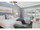 Main bedroom with plush bedding, a sitting bench, and sliding doors opening onto a private pool view at 1695 Honeybear Ln, Dunedin, FL 34698