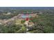 Aerial view showing home's location on spacious lot with a pond nearby at 18010 Okeene Dr, Hudson, FL 34667