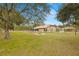 Spacious backyard with fire pit and large oak tree at 18010 Okeene Dr, Hudson, FL 34667