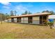 Exterior view of barn with multiple stalls and metal roof at 18010 Okeene Dr, Hudson, FL 34667